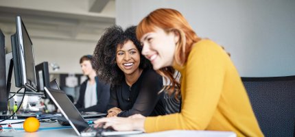 Zwei jungen Studentinnen arbeiten gemeinsam am PC