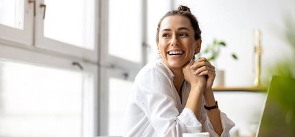Eine junge Frau arbeitet an ihrem Laptop in einem Büro