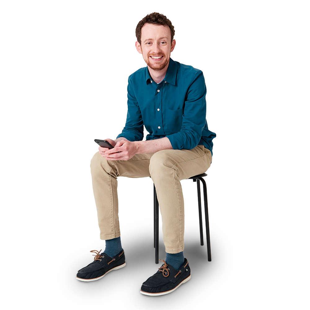 Eine sitzende Person hält ein Smartphone in der Hand 