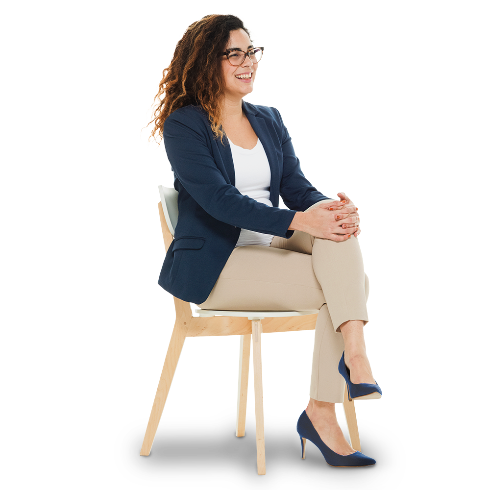 Mitarbeiterin sitzt mit überkreuzten Beinen auf einem Stuhl