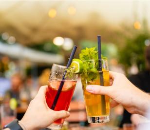 Zwei Hände stoßen mit erfrischenden Cocktails an