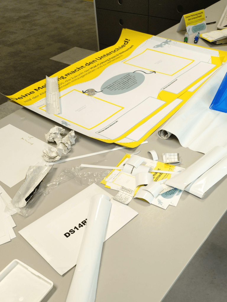 Zettel, Klebestreifen und Plakate auf einem Tisch