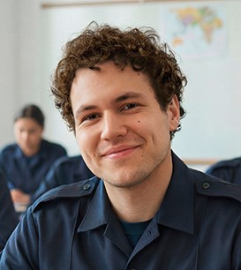 Junger Polizist sitzt in einem Lehrsaal