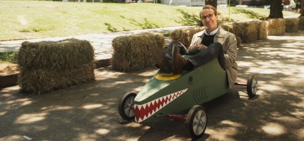 Herr Möller sitzt in einer Krokodil-Seifenkiste.