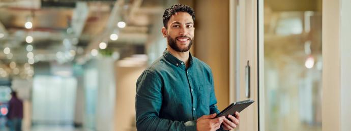 Ein Mann lächelt und hat ein iPad in der Hand