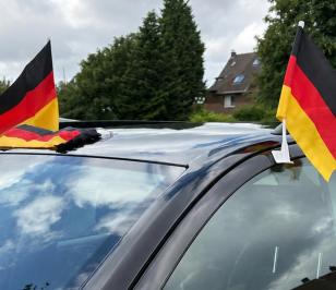 Drei Deutschlandfahnen an einem Auto befestigt zur Fußball WM