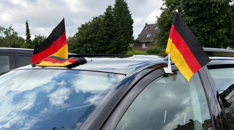 Drei Deutschlandfahnen an einem Auto befestigt zur Fußball WM