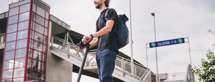 Mann mit E-Scooter in der Stadt