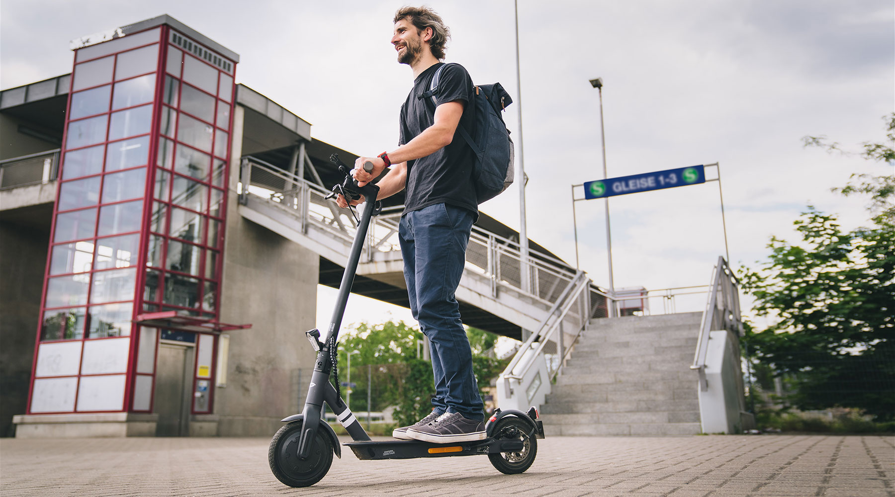 Mann fährt auf einem E-Scooter.