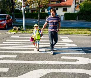 Vater bringt sein Kind über die Straße