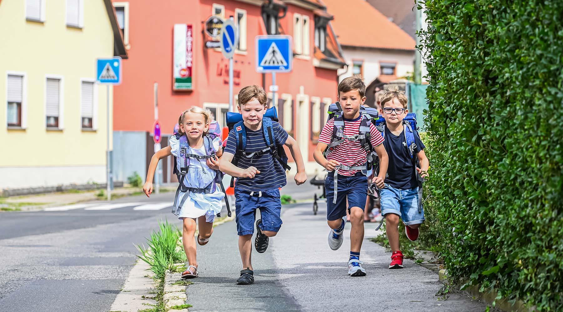 Schulkinder rennen auf dem Bürgersteig