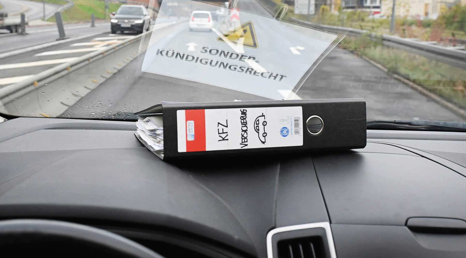 Kfz-Ordner liegt auf einem Amaturenbrett im Auto