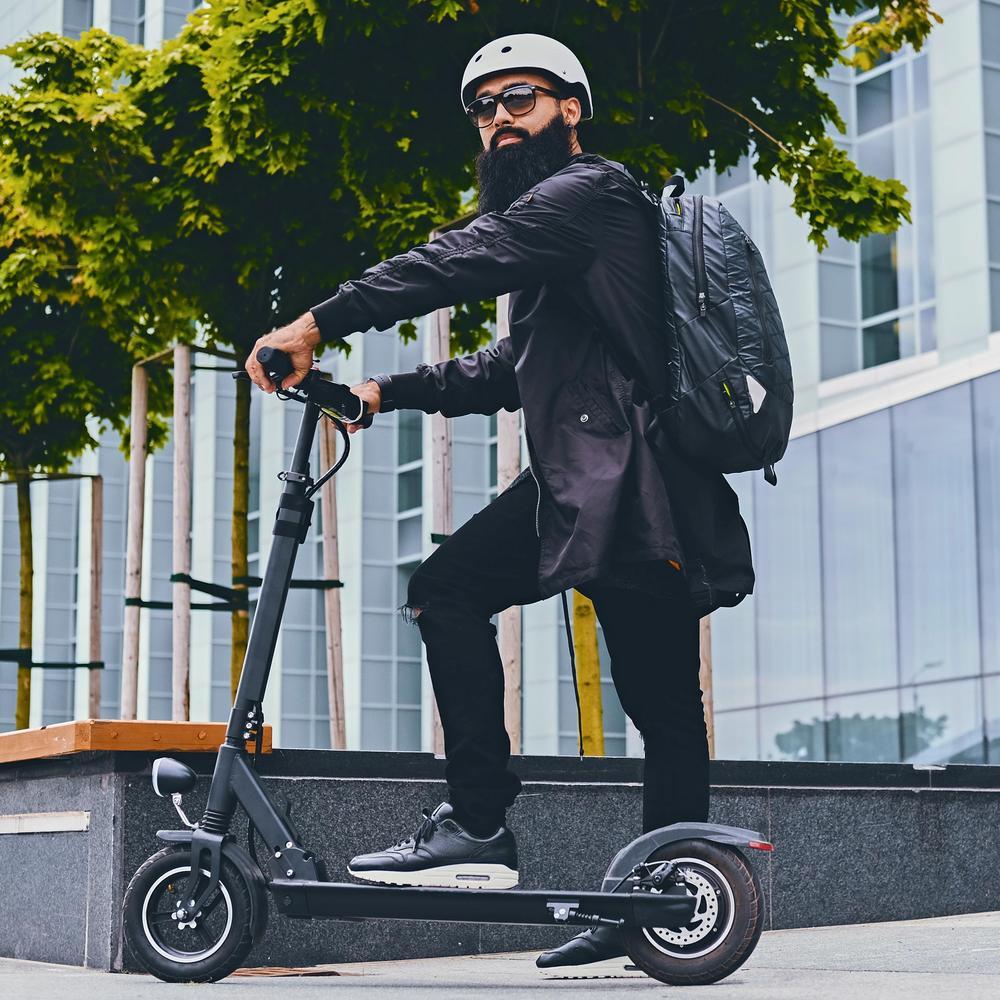 Ein Mann posiert auf Elektro-Roller