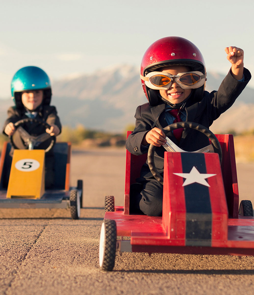 Zwei Kinder fahren ein Seifenkistenrennen.