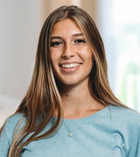 Junge Frau steht und lächelt