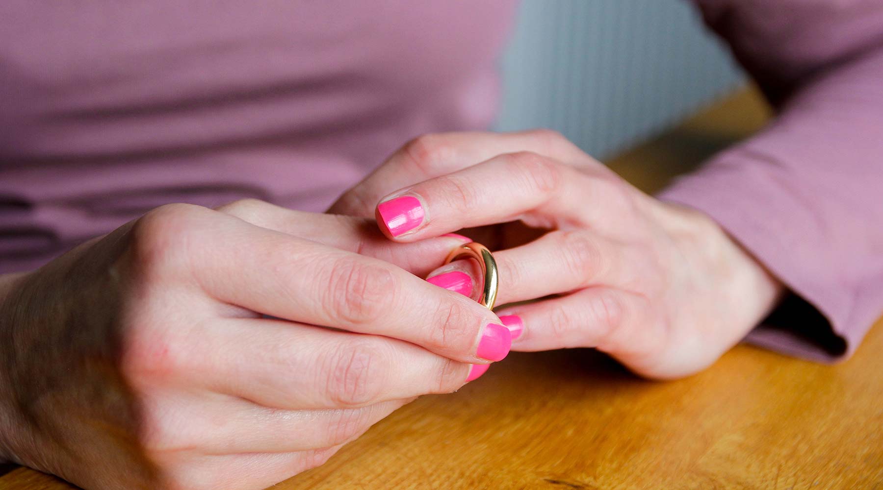 Eine Frau nimmt ihren Ehering ab.
