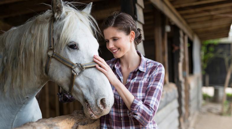 Frau mit Pferd im Stall