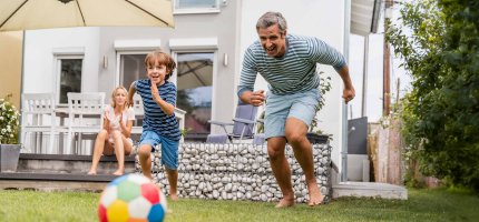 Familie spielt im Garten Frisbee