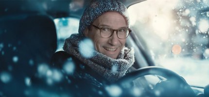 Herr Möller sitzt in einem Auto während es schneit.