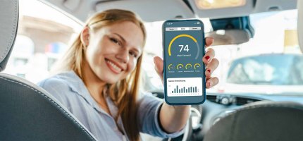 Frau hält ein Smartphone mit der Mein Auto App in die Kamera