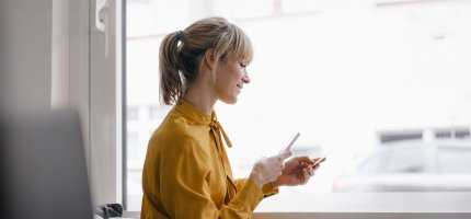 Junge Frau mit Smartphone in der Hand