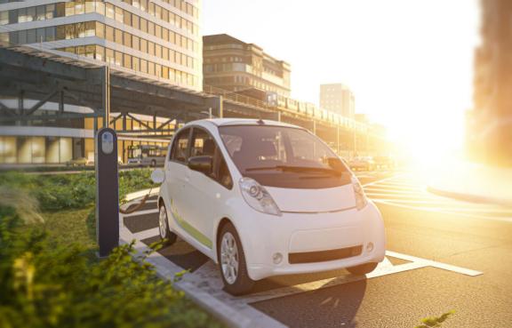Elektroauto lädt in sonniger Stadt an der Strasse
