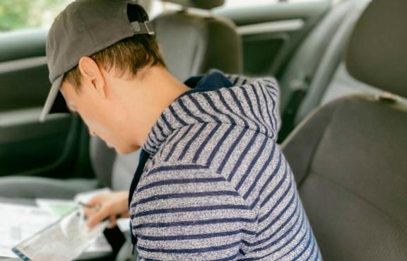 Mann sucht im Auto seinen Fahrzeugschein