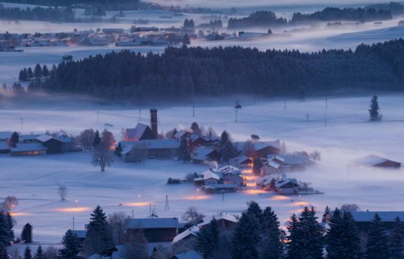 Winterlandschaft mit Häusern und Wälder bei Nacht