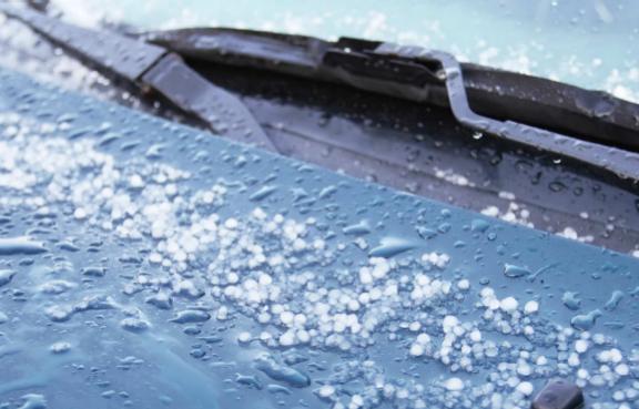 Hagel auf der Motorhaube eines Autos.