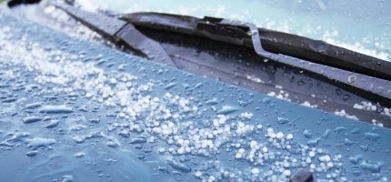 Hagel auf der Motorhaube eines Autos.