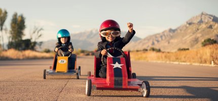 2 Kinder Fahren im Tretauto ein Rennen