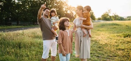 Familie mit 3 Kindern auf einer Wiese