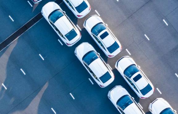 Zwei Reihen weißer Autos von oben.