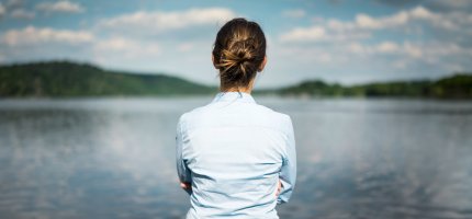 Frau schaut auf einen See