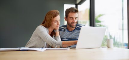 Zwei junge Menschen vor einem Laptop