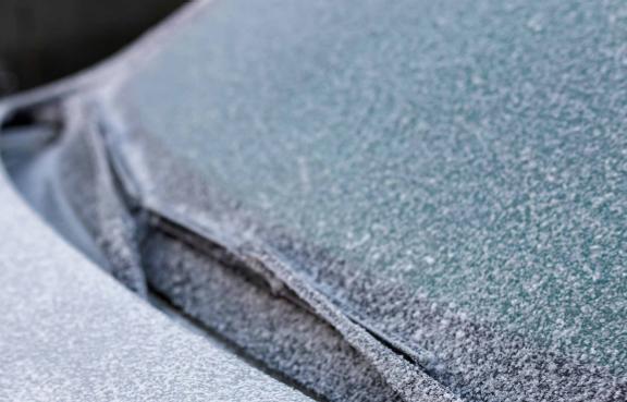 Eine Autoscheibe ist mit einer dünnen Schicht aus Frost bedeckt.