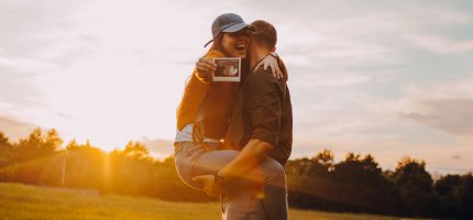 Mann und Frau zeigen ein Ultraschallbild