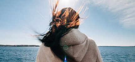 Frau schaut auf das Meer