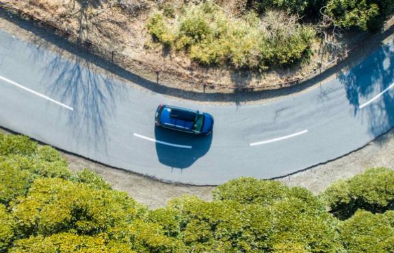 Ein Auto von oben wie es in eine Kurve fährt.