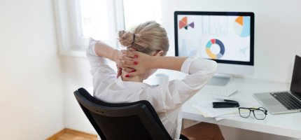 Frau im Büro hält sich den Nacken