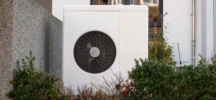 Wärmepumpe im Vorgarten eines Hauses