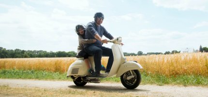 Vater mit Kind auf Roller