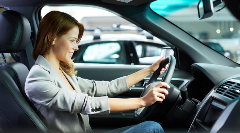 Eine Frau sitzt hinter dem Steuer eines Autos.