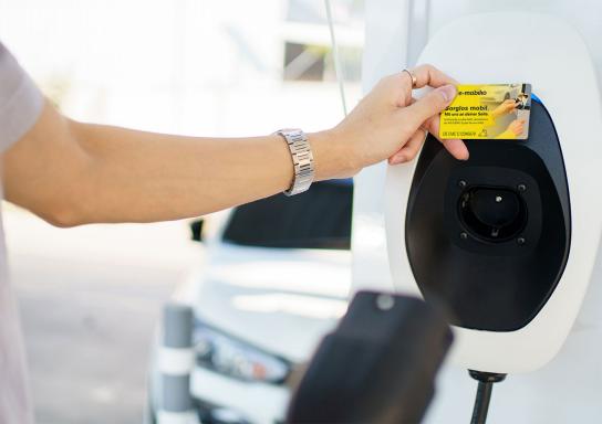 Mann lädt Elektroauto an öffentlicher Ladestation.