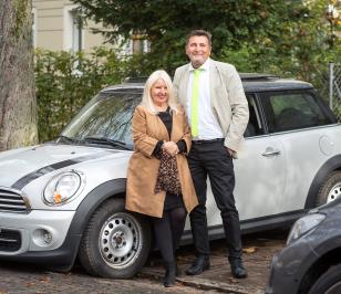 Kunde der HUK-COBURG mit seiner Frau vor seinem Mini