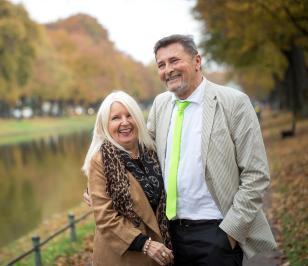 Kunde der HUK-COBURG mit seiner Frau im Arm an einem Fluss