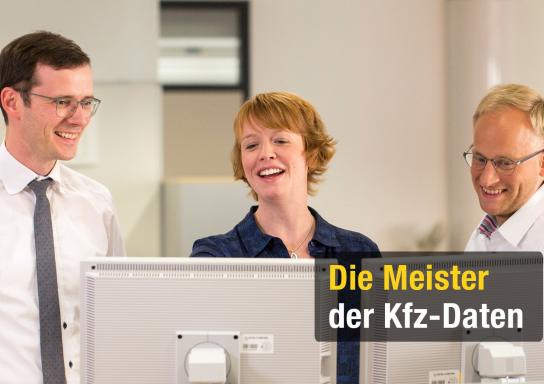 3 Mitarbeiter der HUK stehen an einem Computer und unterhalten sich. Rechts ein blonder Mann mit Brille, in der Mitte eine Frau mit hellbraunen Harren und links ein dunkelhaariger Mann mit Brille. Alle drei lachen.