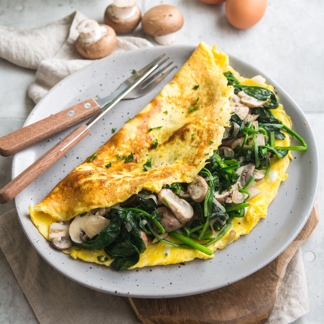 Omelette mit Spinat und Champignons gefüllt