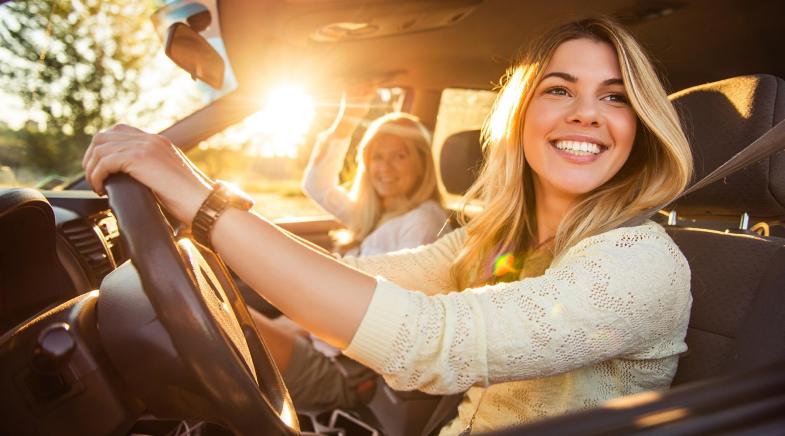 Blick aus einem Auto auf zwei Frauen, die sich unterhalten und spazieren gehen..