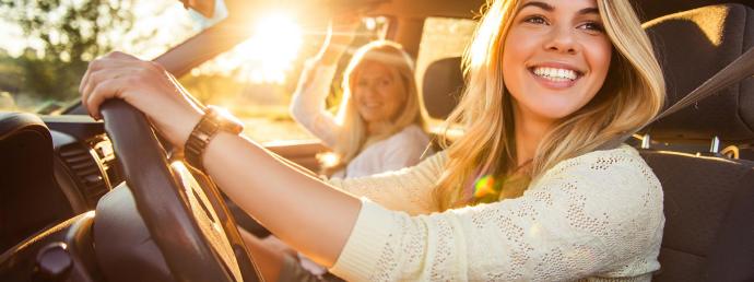 Blick aus einem Auto auf zwei Frauen, die sich unterhalten und spazieren gehen..